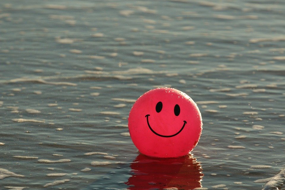 Imagem de bola vermelha com sorriso sobre as águas