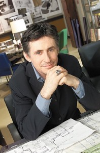 Imagem do ator Gabriel Byrne sentado com papeis lembrando processo de criação.